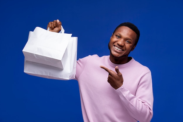 Foto grátis homem sorridente de tiro médio segurando bolsa