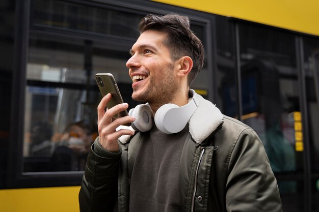 Homem sorridente de tiro médio segurando o telefone