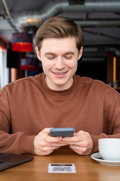 Homem sorridente de tiro médio segurando smartphone