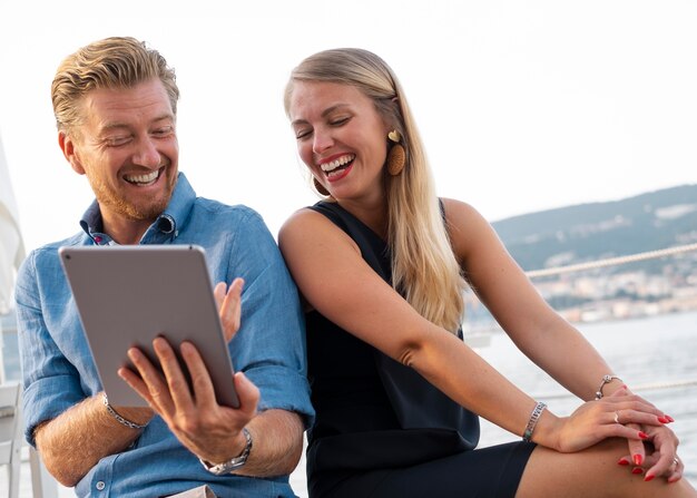 Homem sorridente de tiro médio segurando tablet