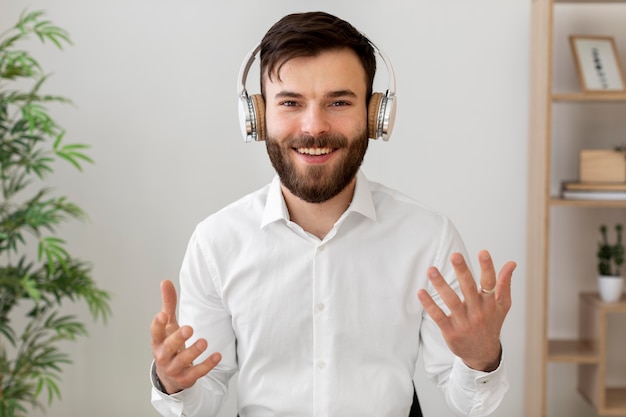 Homem sorridente de tiro médio usando fones de ouvido