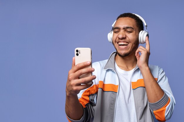 Foto grátis homem sorridente de tiro médio usando fones de ouvido