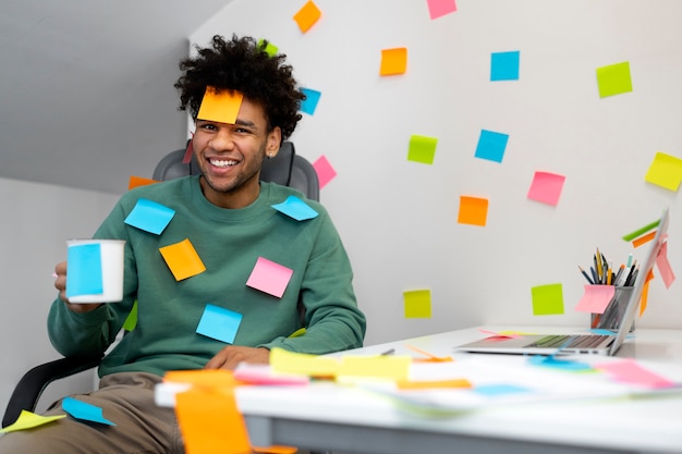 Homem sorridente de tiro médio usando post-it