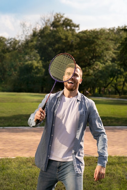 Foto grátis homem sorridente de vista frontal jogando badminton