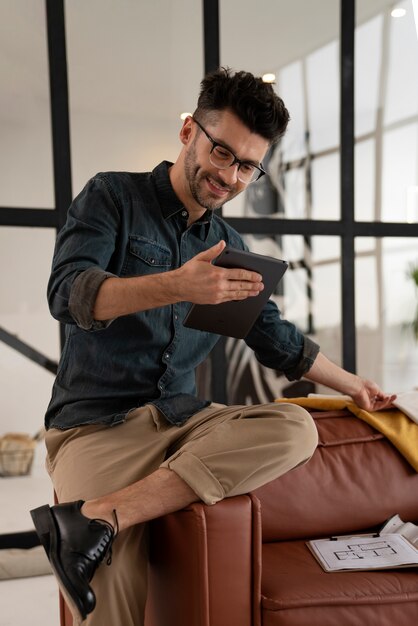 Homem sorridente de vista frontal segurando o tablet