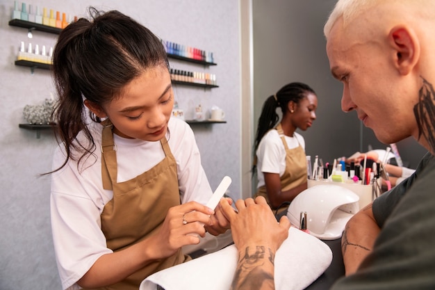 Foto grátis homem sorridente de vista lateral fazendo manicure