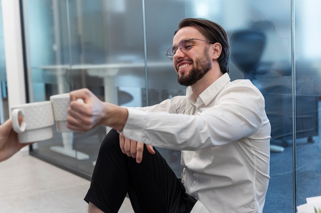 Homem sorridente de vista lateral segurando a xícara