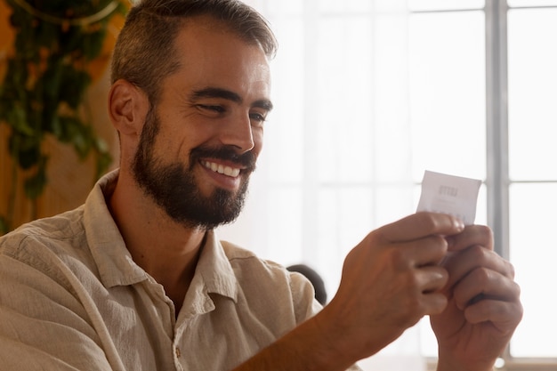 Foto grátis homem sorridente de vista lateral segurando o bilhete