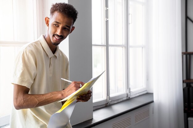 Homem sorridente de vista lateral tomando notas