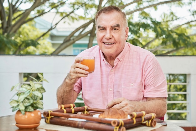 Foto grátis homem sorridente, desfrutando de suco fresco