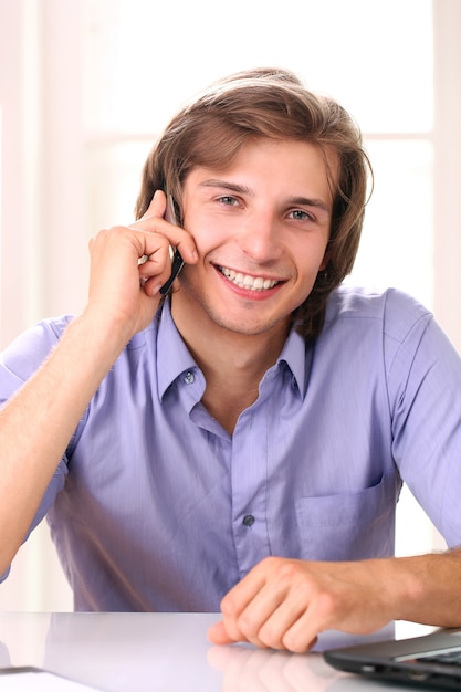 Homem sorridente, falando pelo celular