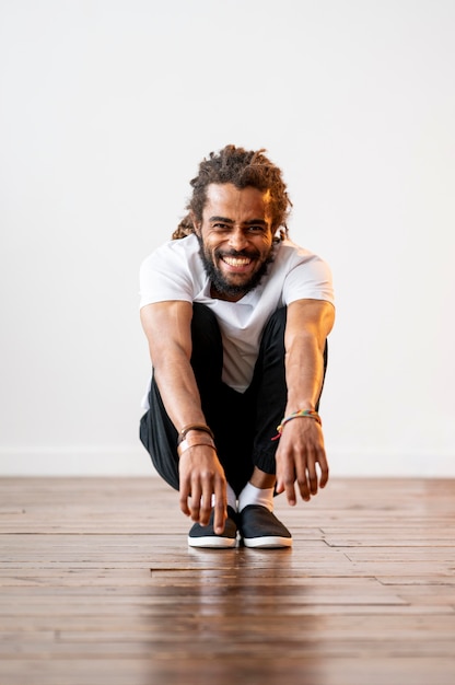 Foto grátis homem sorridente fazendo um agachamento