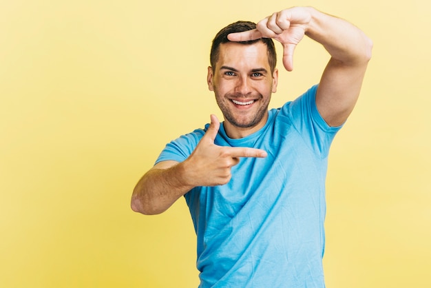 Foto grátis homem sorridente, fazendo um quadro com os dedos