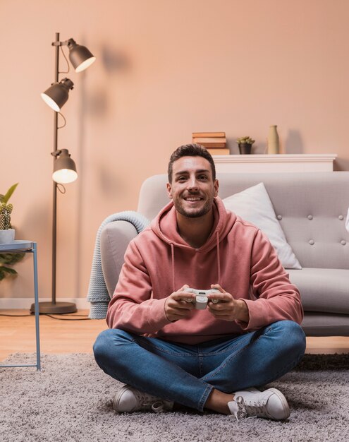 Homem sorridente no chão, jogando jogos