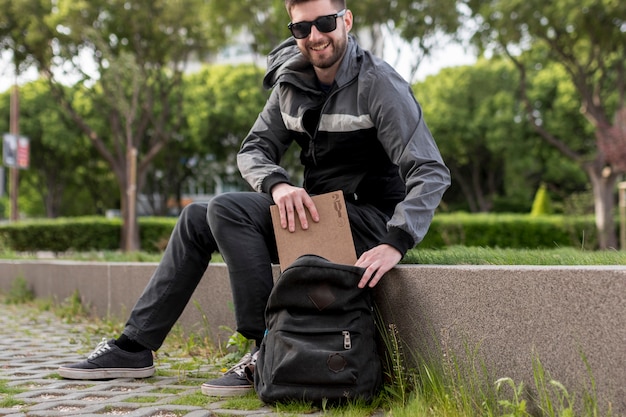 Homem sorridente, pôr livro, em, mochila