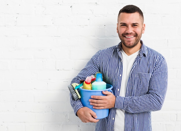 Foto grátis homem sorridente posando com produtos de limpeza e cópia espaço