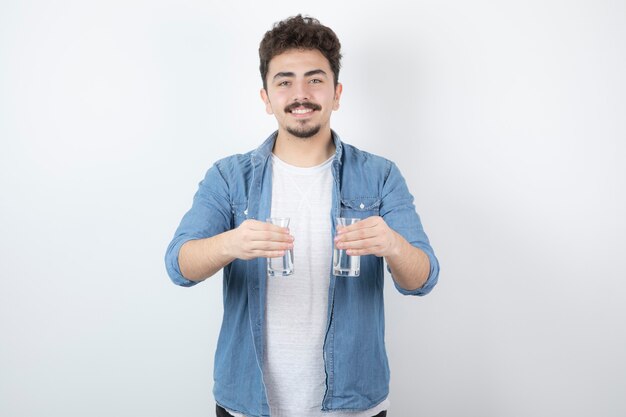 homem sorridente segurando um copo de água em branco.
