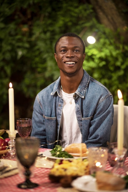 Homem sorridente sentado à mesa vista frontal