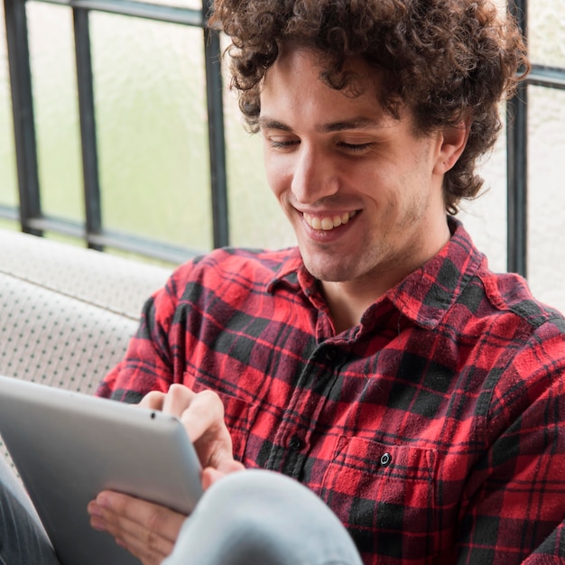 Foto grátis homem sorridente trabalhando no tablet