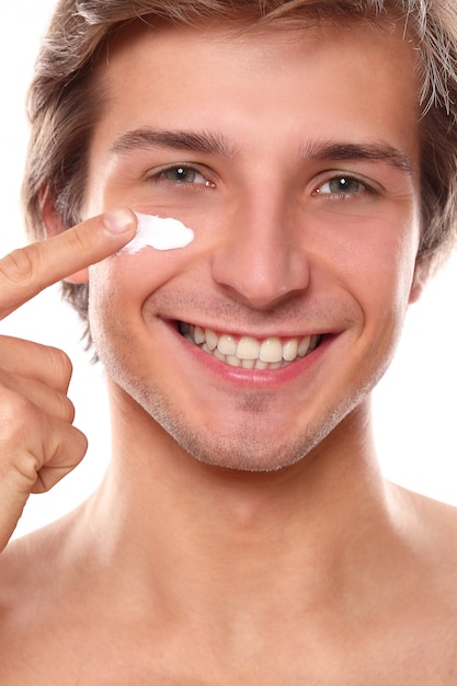 Homem sorridente usando creme facial