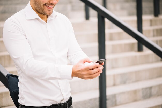 Homem sorridente usando o smartphone