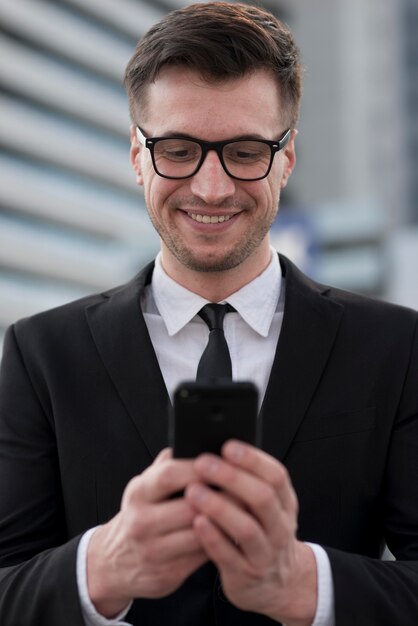 Homem sorridente, verificando móvel