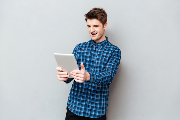 Foto grátis homem surpreendido olhando para tablet computador isolado