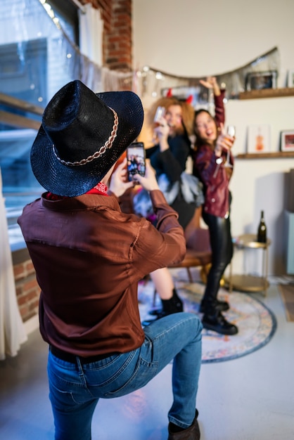 Homem tirando fotos de amigos na festa