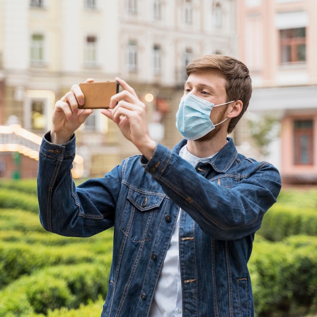 Homem tirando uma foto usando uma máscara facial