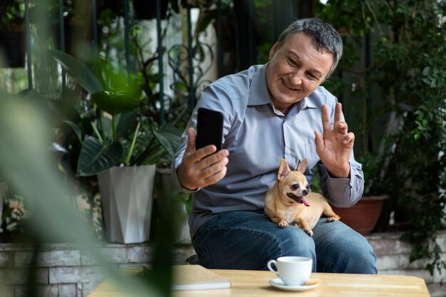 Homem tirando uma selfie com seu cachorro no jardim