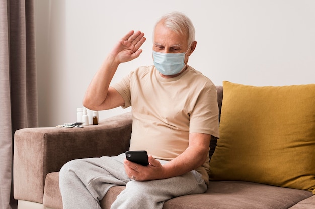 Foto grátis homem tiro médio acenando para smartphone