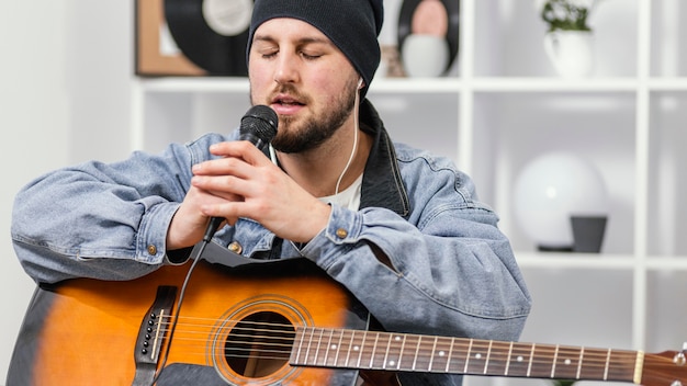 Foto grátis homem tiro médio cantando dentro de casa