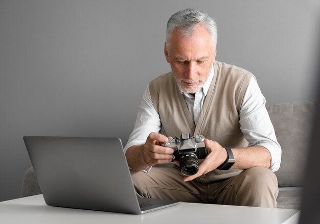 Foto grátis homem tiro médio com câmera fotográfica