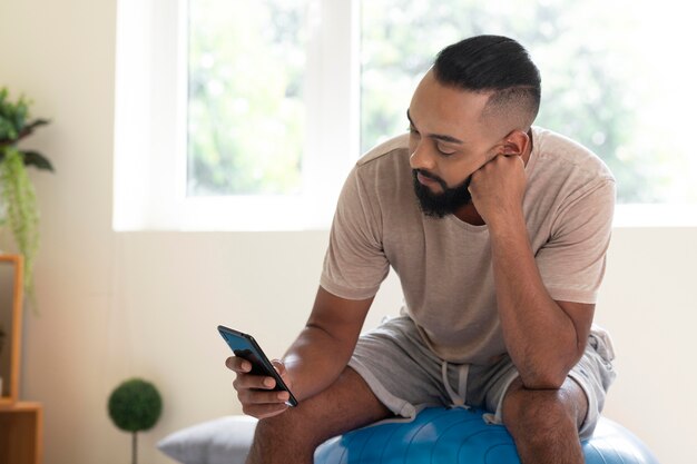 Foto grátis homem tiro médio segurando smartphone