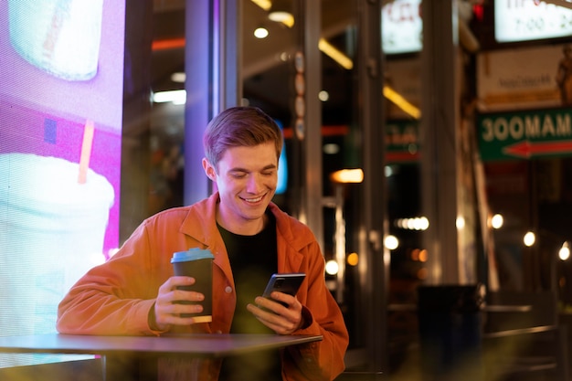 Foto grátis homem tiro médio segurando smartphone