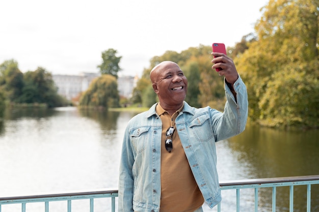 Foto grátis homem tiro médio segurando smartphone