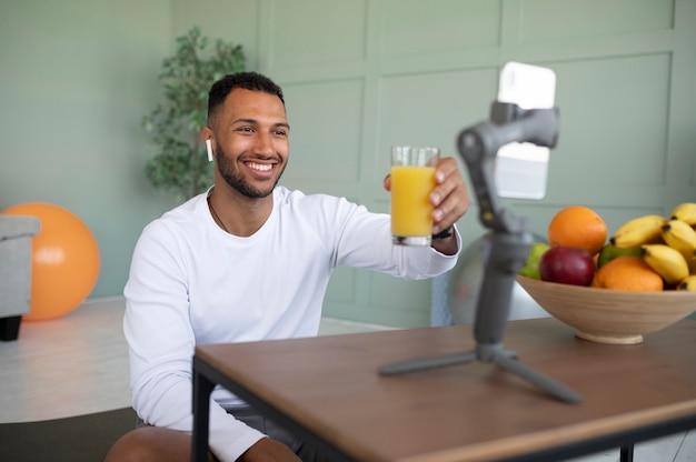 Homem tiro médio segurando um copo de suco