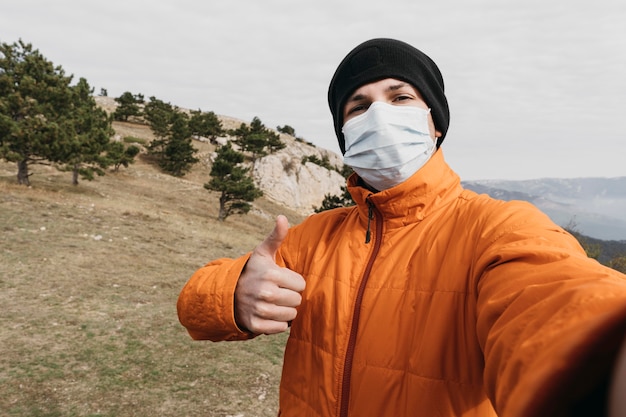 Homem tiro médio tirando selfie com máscara