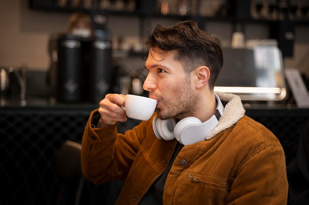 Homem tiro médio tomando café