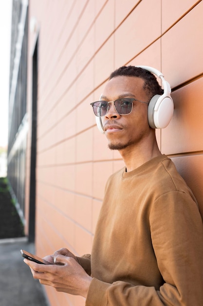 Foto grátis homem tiro médio usando fones de ouvido