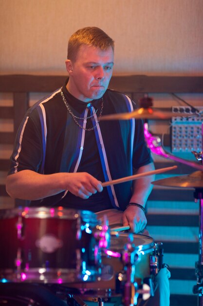 Homem tocando bateria durante apresentação em um evento local