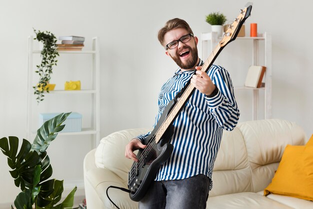 Homem tocando guitarra em casa