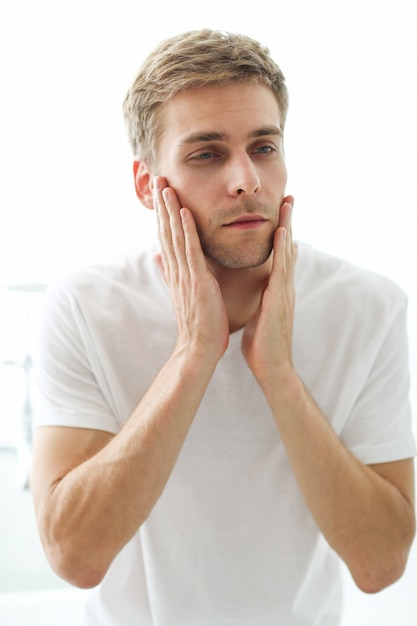 Homem tocando sua barba, pronta para fazer a barba.