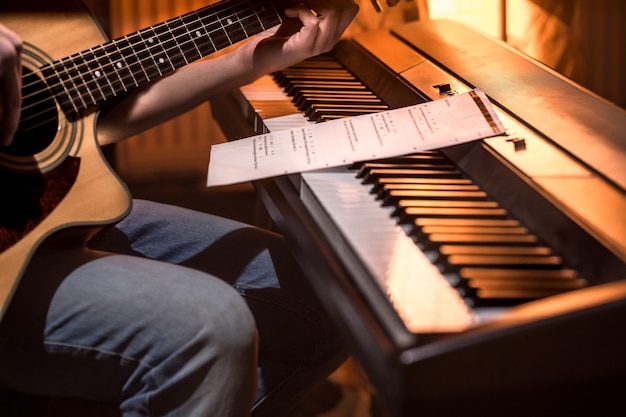Foto grátis homem tocando violão e close-up de piano