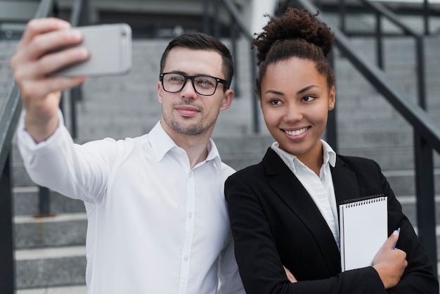 Homem tomando selfie com colega de trabalho