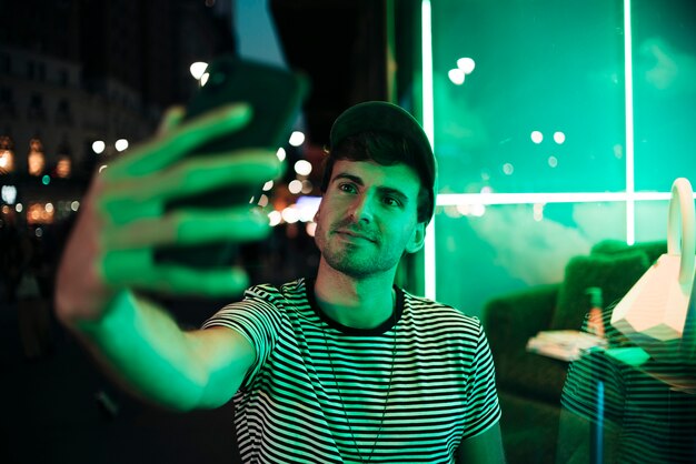 Homem tomando uma selfie no meio da noite