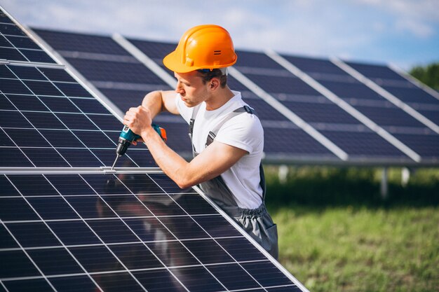 Homem trabalhador no firld pelos painéis solares