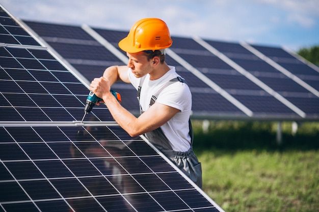 Homem trabalhador no firld pelos painéis solares