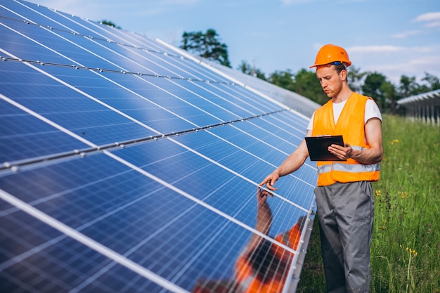 Homem trabalhador no firld pelos painéis solares