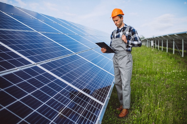 Homem trabalhador no firld pelos painéis solares